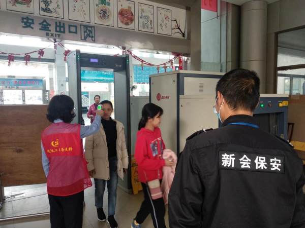 （第9期）新会汽车总站工作人员在旅客出口处对旅客进行体温检测.jpg